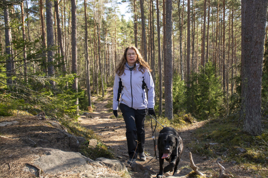 Riikka Mantila ulkoiluttaa Mauno-koiraa ulkoilupolulla.