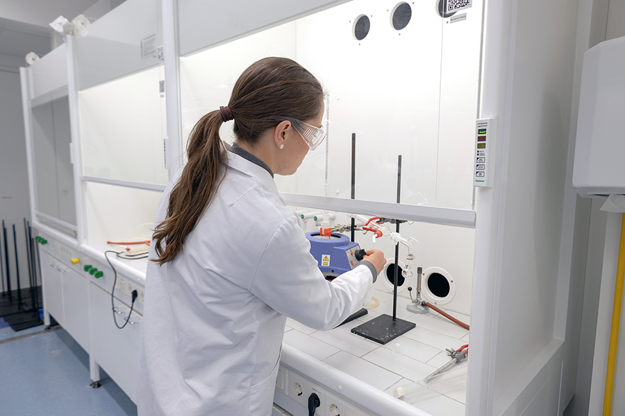 Nuori naisoletettu laittaa laboratoriossa kaasulämmitintä päälle tai jotain vastaavaa.