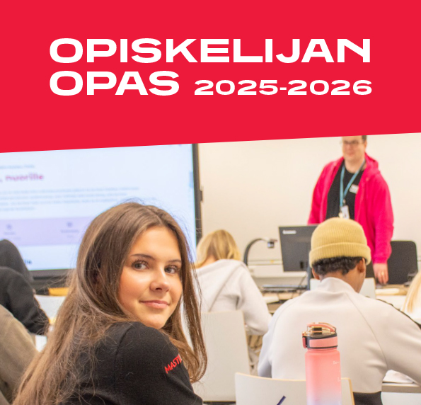 TAIn Opiskelijan oppaan 2025-2026 -kansikuvassa nuori naisoletettu katsoo luokassa kameraan. Taustalla näkyy muita opiskelijoita ja opettaja.