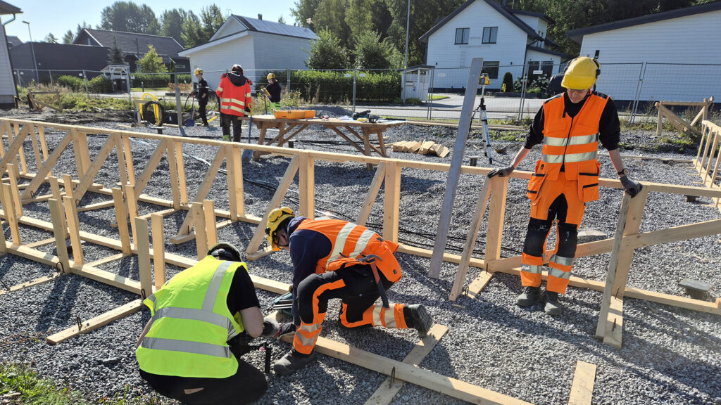 Rakentajat pystyttävät omakotitalon runkoa rakennustyömaalla.