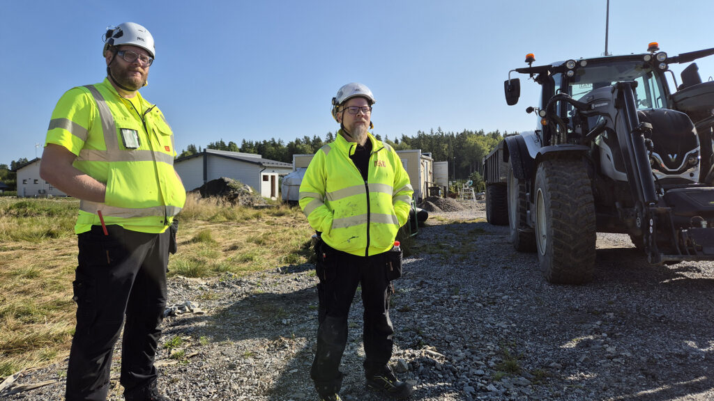 Teemu Taalikka ja Jouni Ruotsalainen seisovat Yli-Maarian rakennustyömaalla traktorin vieressä.