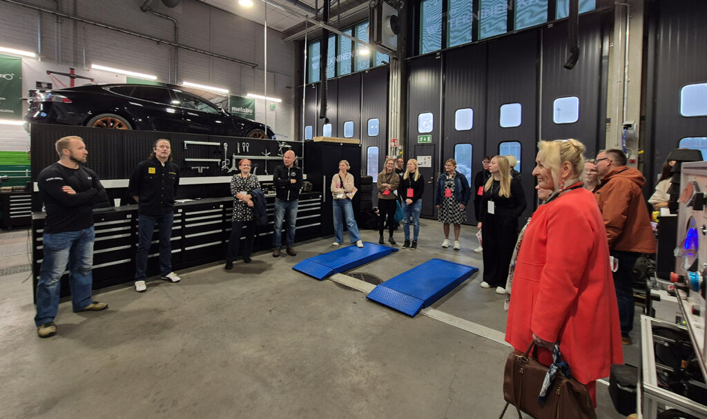 Opot kuuntelevat ajoneuvoalan opettajien puhetta työpajassa.